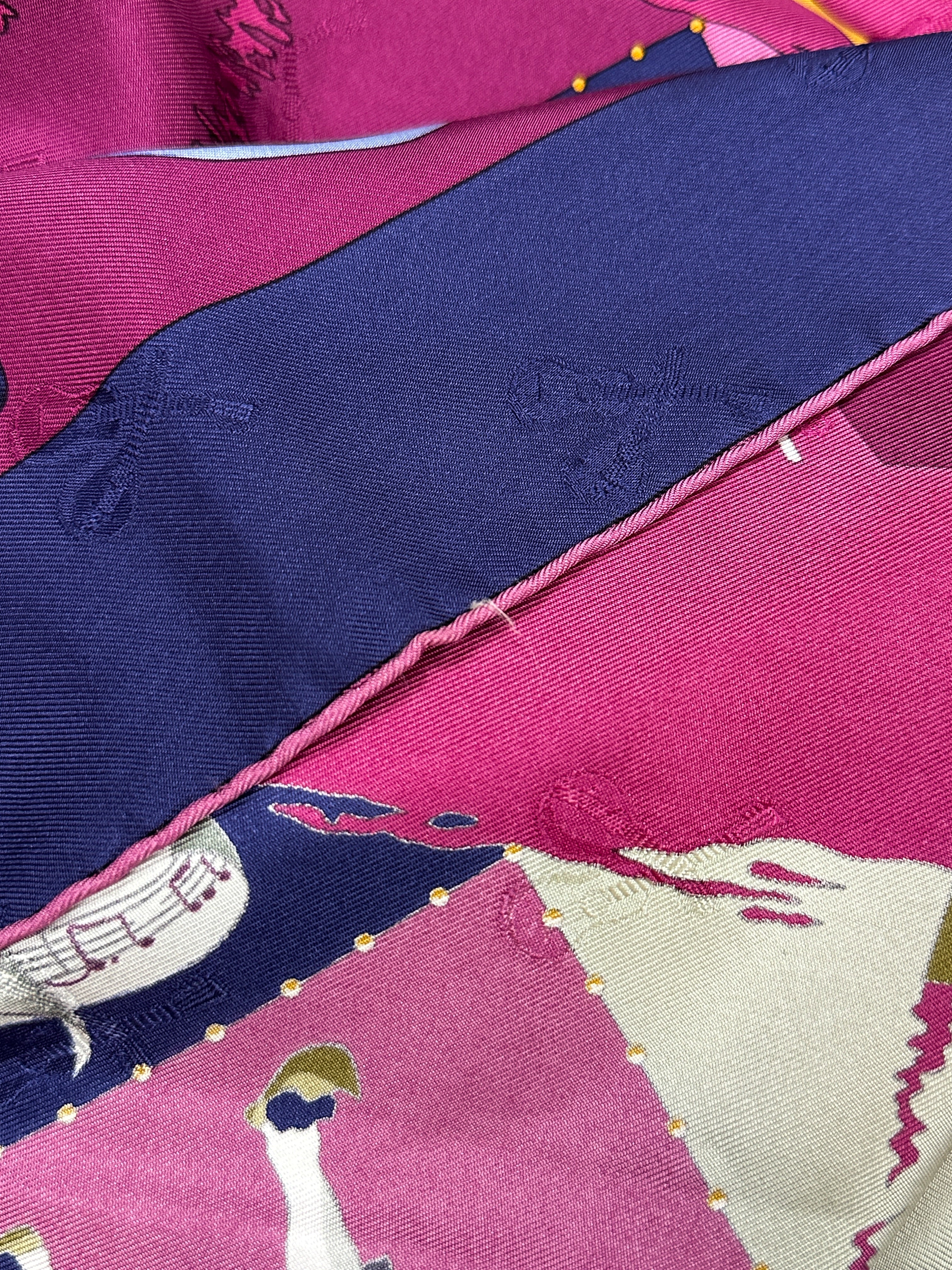 Close-up of a fabric with pink and blue colors and musical notes design.